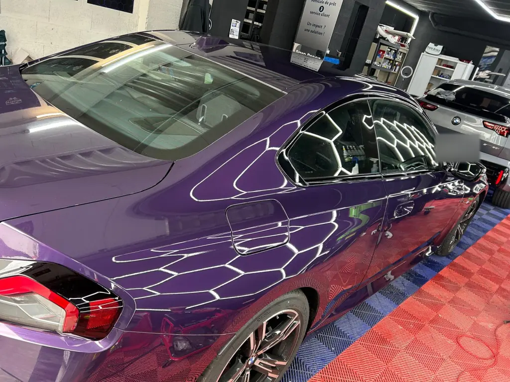 Reflets sur la carrosserie lustrée d’un coupé violet
